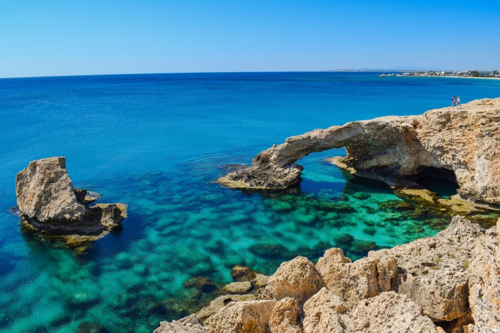 Idyllic coastal view of Cyprus arch and turquoise sea, perfect for summer travel inspiration.